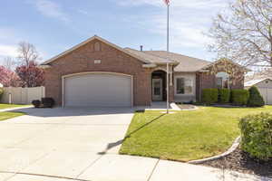 View of front facade featuring an attached garage, concrete driveway, brick siding, and roof