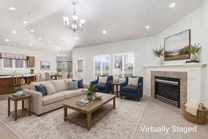Living area featuring suspended lighting, a tile fireplace, and vaulted ceiling (Visually Staged)