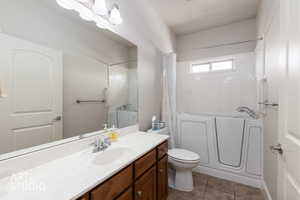 Full Bathroom with vanity, dark tile patterned floors, and shower / bathtub combination with curtain