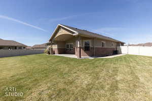 Rear view of property featuring brick siding,  covered patio, and fenced backyard, and a patio