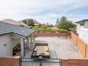 Fenced backyard with a patio area, a gate, and a residential view
