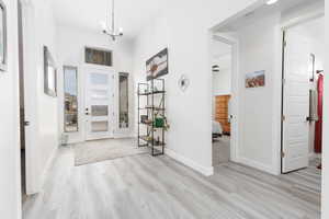 Entryway with a chandelier, light wood-style flooring, and a high ceiling
