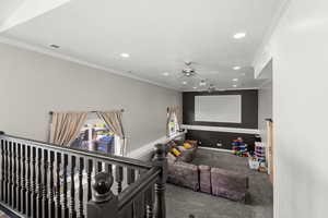 Cinema room featuring a ceiling fan, ornamental molding, recessed lighting, and carpet floors