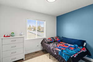 Bedroom featuring wood finished floors and baseboards