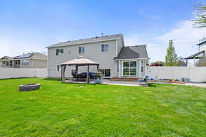 Rear view of property with an outdoor fire pit, a gazebo, a patio, a fenced backyard, and roof with shingles