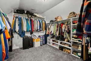 Walk in closet featuring carpet flooring and lofted ceiling