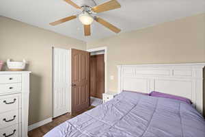 Bedroom with dark wood-type flooring and a ceiling fan