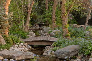 View of private river and bridge located inside fenced backyard