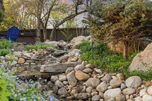 View of private river and bridge located inside fenced backyard