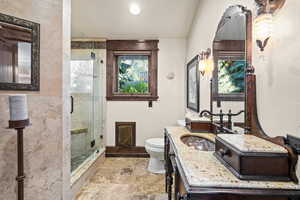 Full bathroom featuring vanity, a shower stall, stone tile floors, and recessed lighting