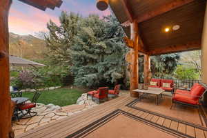 Wooden deck with a patio, an outdoor hangout area, and a fenced backyard