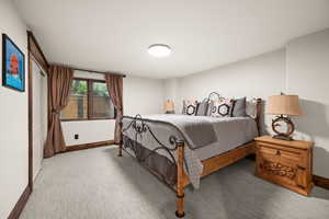 Bedroom with baseboards and light carpet