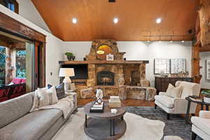 Living area featuring wood finished floors, recessed lighting, a fireplace, and lofted ceiling