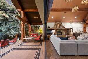 Outdoor / Indoor Living area with lofted ceiling, hardwood / wood-style floors, and a fireplace
