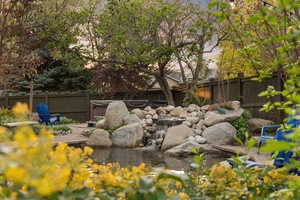 Fenced backyard with a small pond