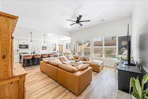 Living room featuring light wood-style flooring, a ceiling fan, and recessed lighting