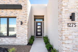 Doorway to property featuring stucco siding