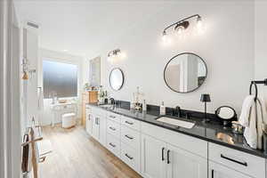 Bathroom featuring double vanity and light wood-style flooring