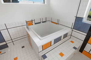 Bathroom with a bath, tile walls, and light tile patterned flooring