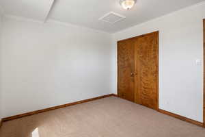 Unfurnished bedroom featuring light colored carpet, a closet, and ornamental molding