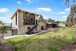 Back of property featuring a deck, brick siding, and a gate