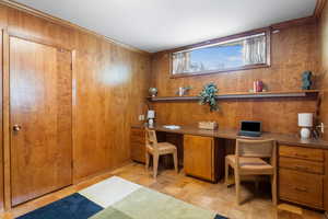 Office with built in study area, wooden walls, and parquet floors