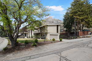 View of front of property with an attached garage, a mountain view, a balcony, and driveway