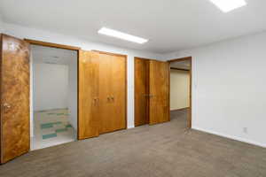 Unfurnished bedroom with light carpet and multiple closets