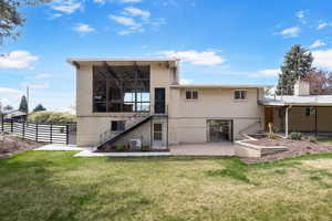 Back of house with a patio area, brick siding, and a balcony