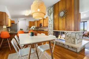 Dining space with light wood-type flooring and a stone fireplace