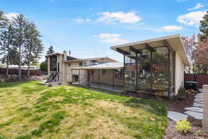 Back of property with a patio and a sunroom