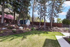 Fenced backyard featuring a storage shed