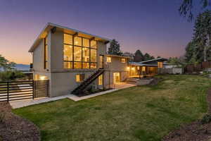 Back of house at dusk with brick siding and a deck