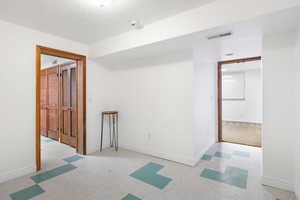 Unfurnished room with baseboards and light flooring