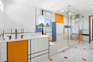 Bathroom with a shower stall, light tile patterned flooring, a garden tub, recessed lighting, and tile walls