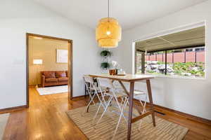 Dining area featuring light wood-type flooring and vaulted ceiling