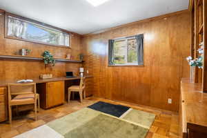 Office area with built in desk and wooden walls