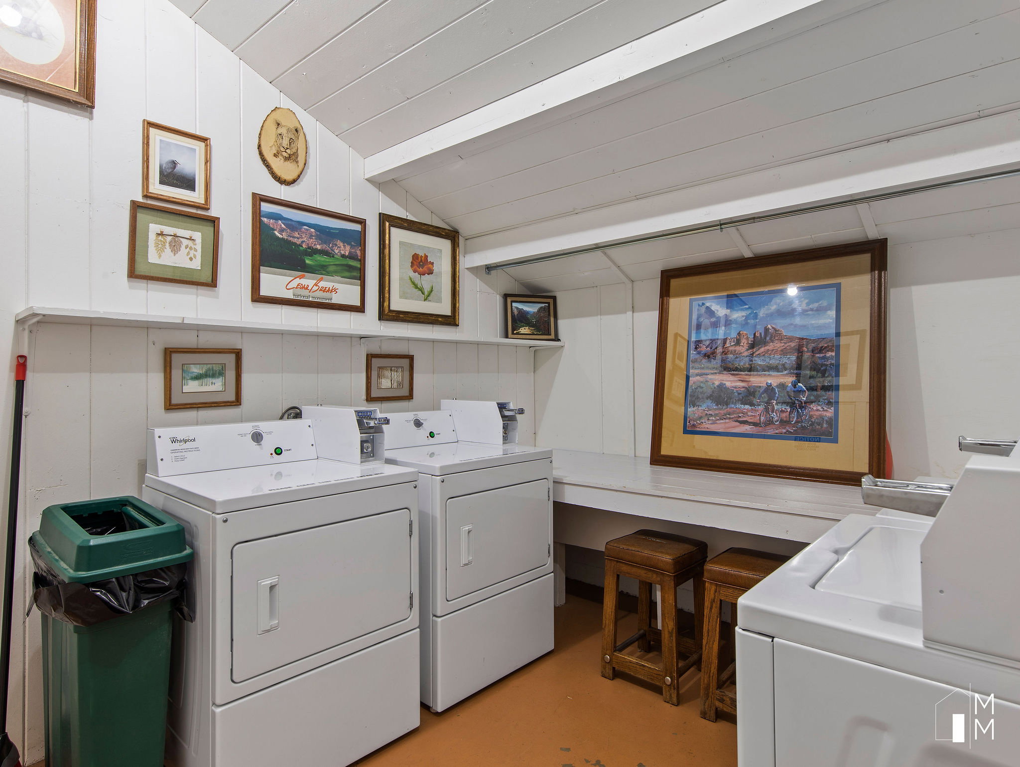 Shared laundry room featuring lofted ceiling, washer and dryer, and finished concrete floors