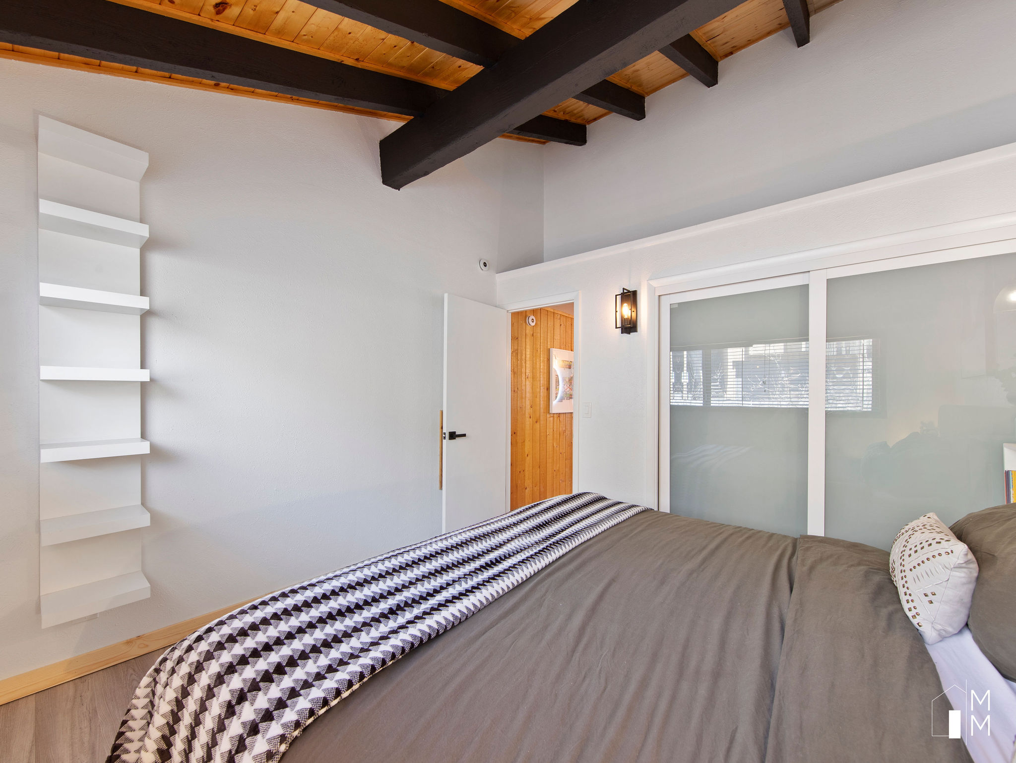 Bedroom featuring a closet and a wood ceiling with exposed beams