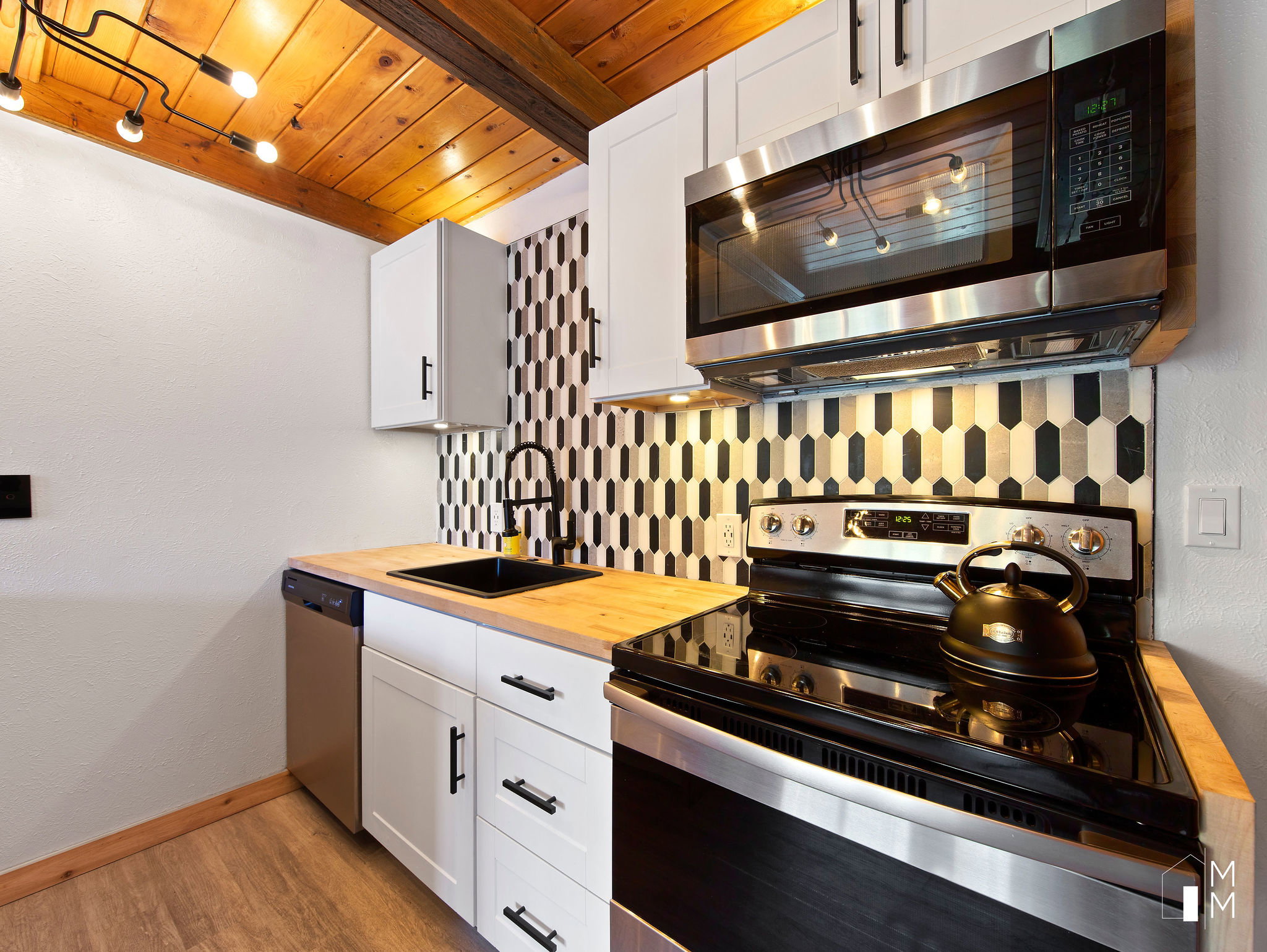 Kitchen featuring stainless steel appliances, butcher block counters, backsplash, white cabinets, and wood ceiling