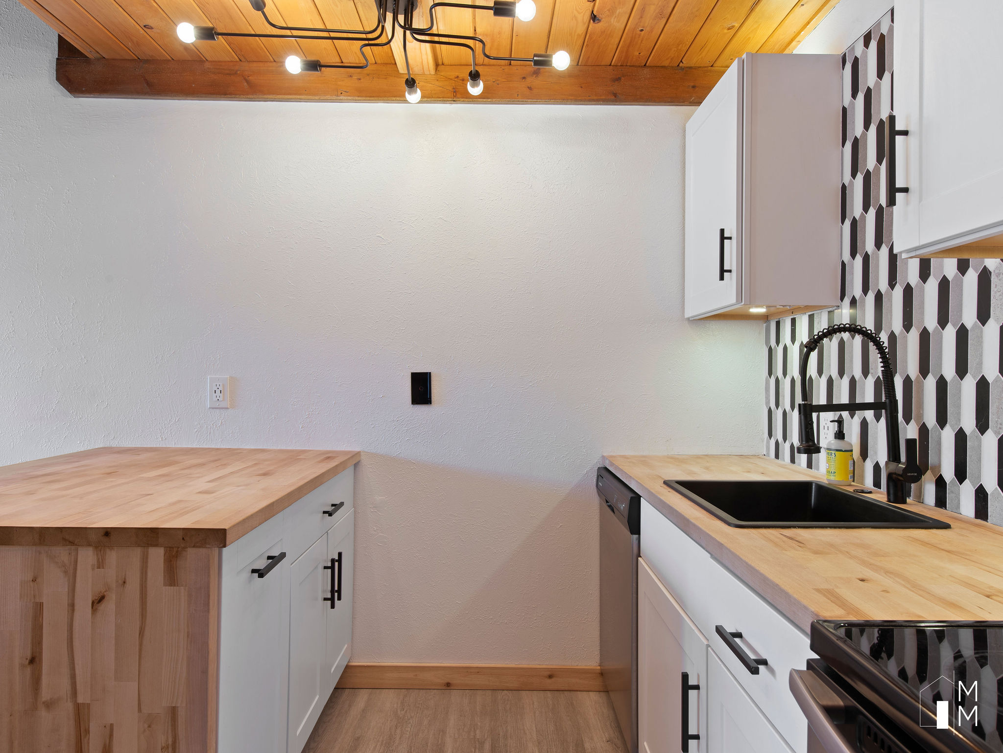 Kitchen with butcher block countertops, white cabinetry, backsplash, wooden ceiling, and dishwasher