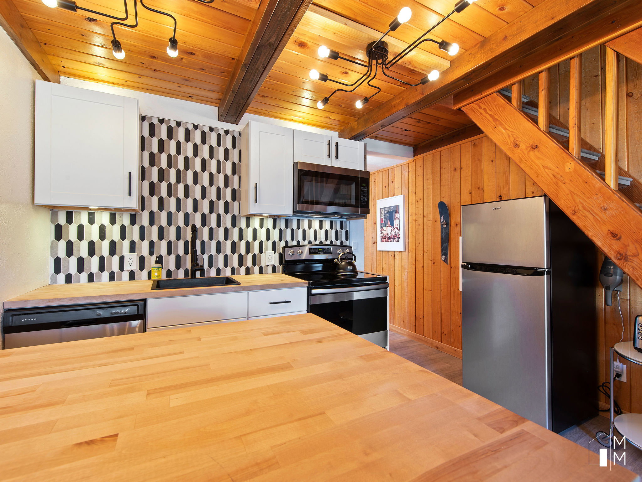Kitchen with wood counters, stainless steel appliances, white cabinets, a wood ceiling with exposed beams, and decorative backsplash