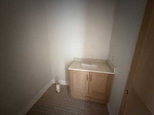 Bathroom with vanity and dark tile patterned floors