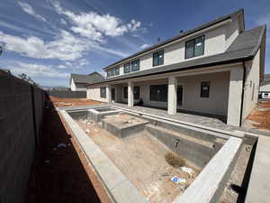 Rear view of house featuring a patio, stucco siding, a fenced backyard, and a tile roof