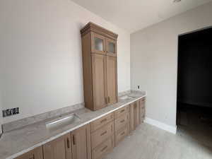 Bathroom with double vanity and baseboards