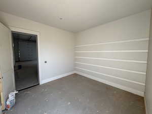 Empty room with concrete flooring and baseboards