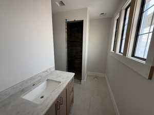 Bathroom featuring vanity and tiled shower