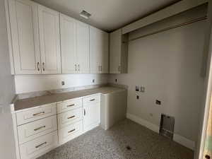 Laundry room with gas dryer hookup, cabinet space, washer hookup, dark aggregate flooring, and hookup for an electric dryer