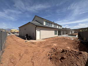 Back of house with a fenced backyard, stucco siding, and a patio area