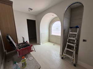 Miscellaneous room featuring arched walkways and baseboards